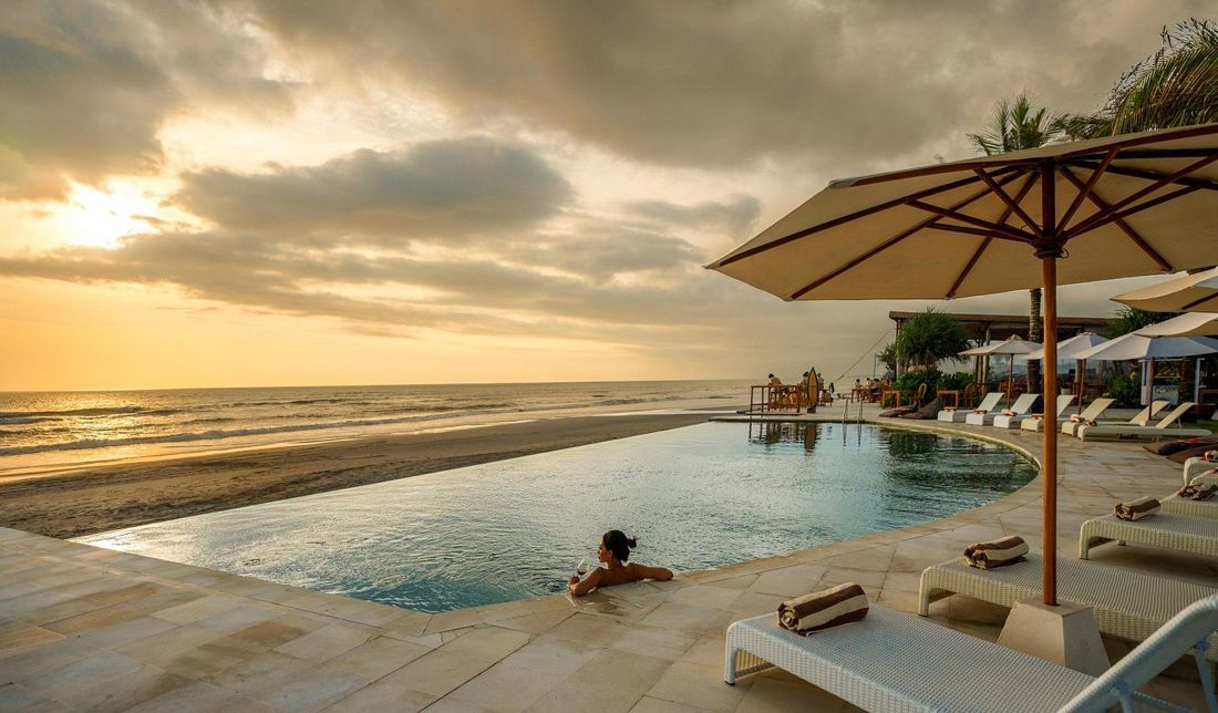 Infinity pool on the beach at sunset