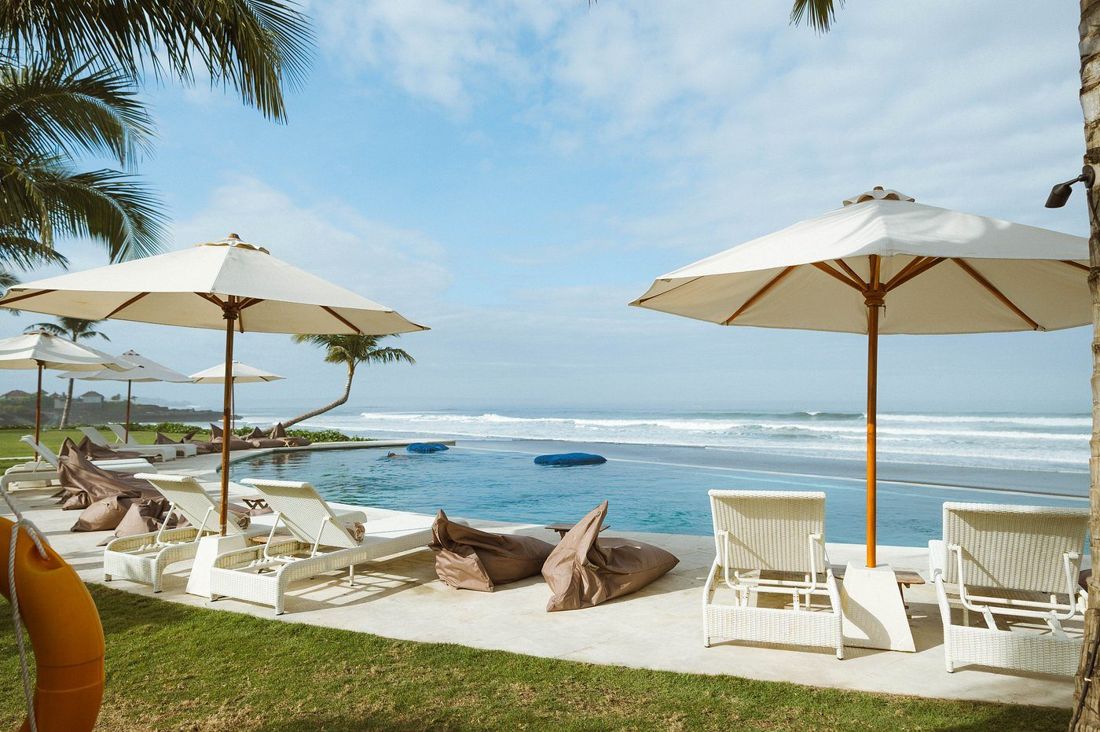 Beachfront pool with umbrellas and loungers