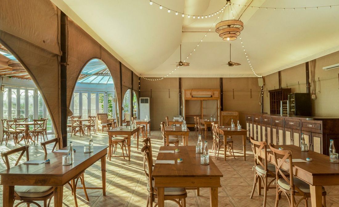 The restaurant tent with long wooden tables